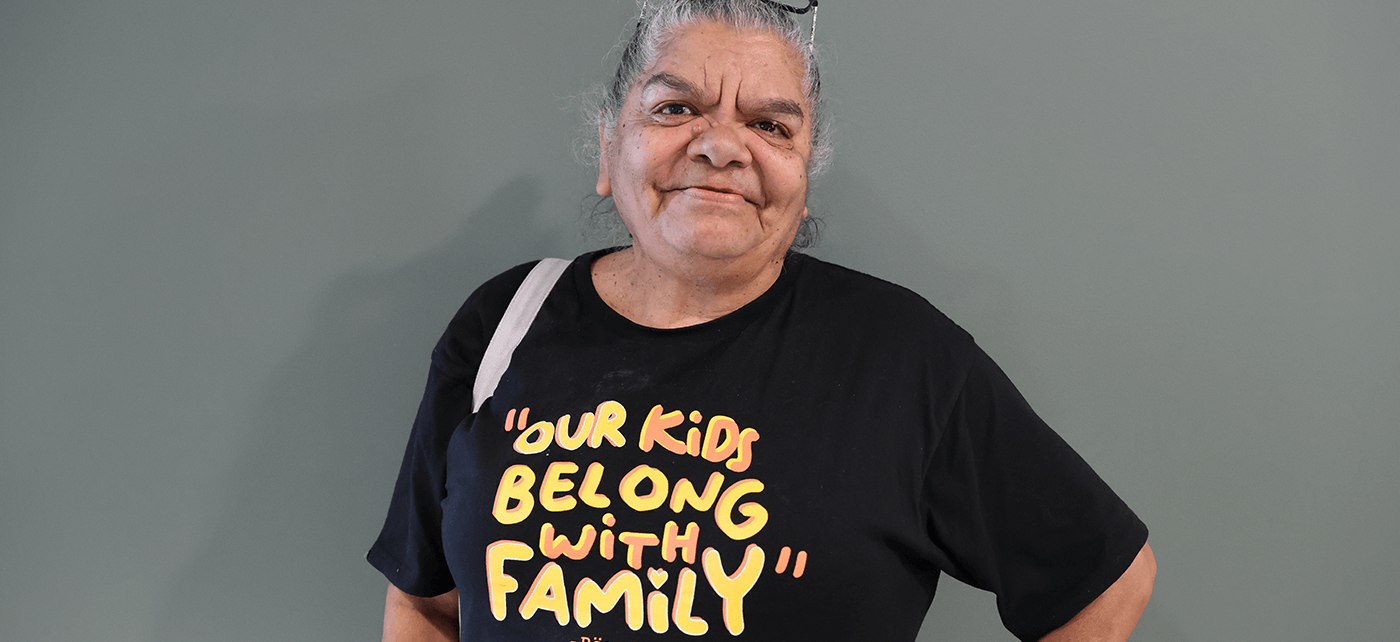 Aunty Rieo Ellis, Grandmothers Against Removal wearing a "our kids belong with family" t-shirt